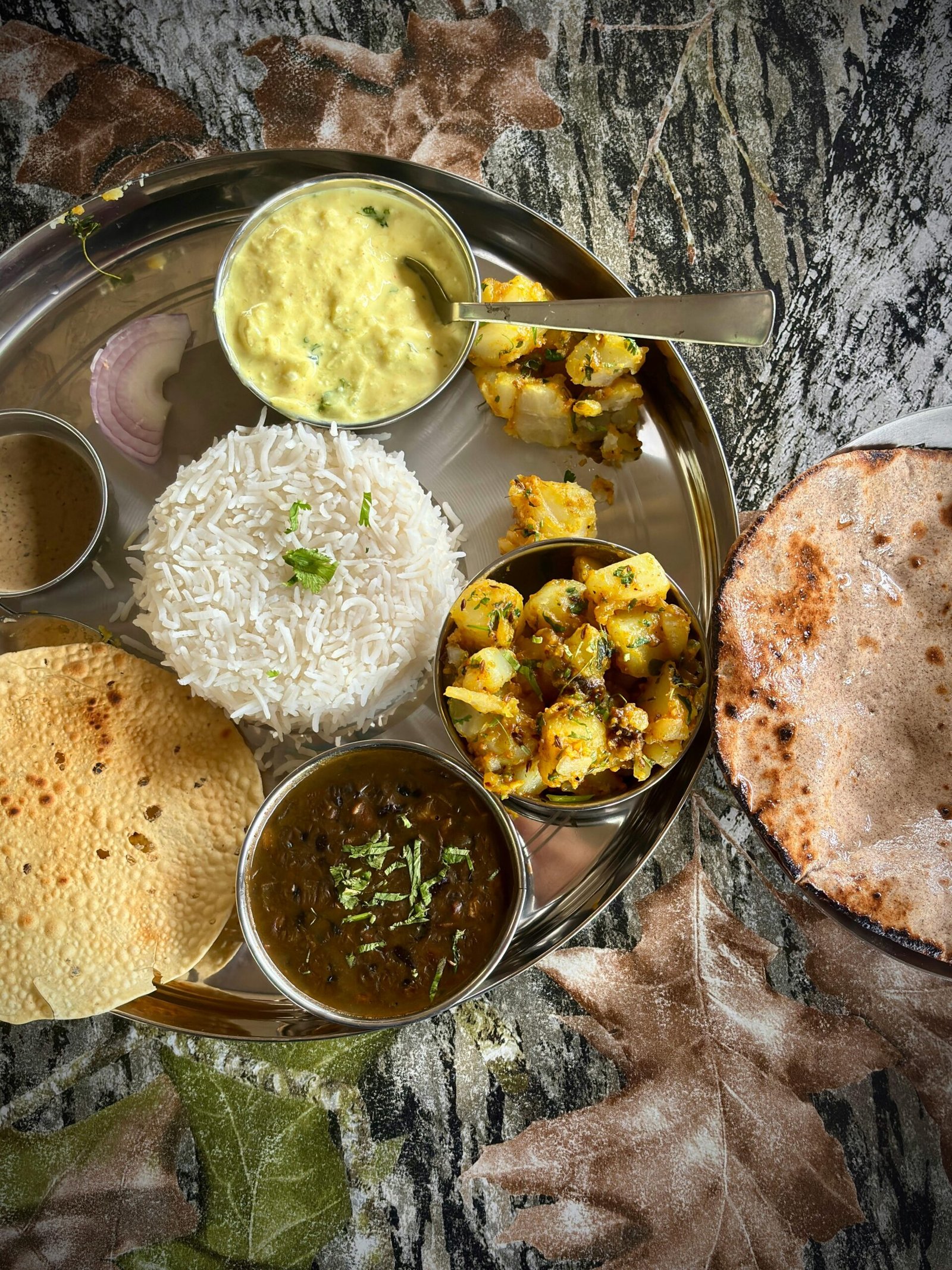 Indian steel thali with dal rice sabzi and roti showing correct portion structure for weight loss
