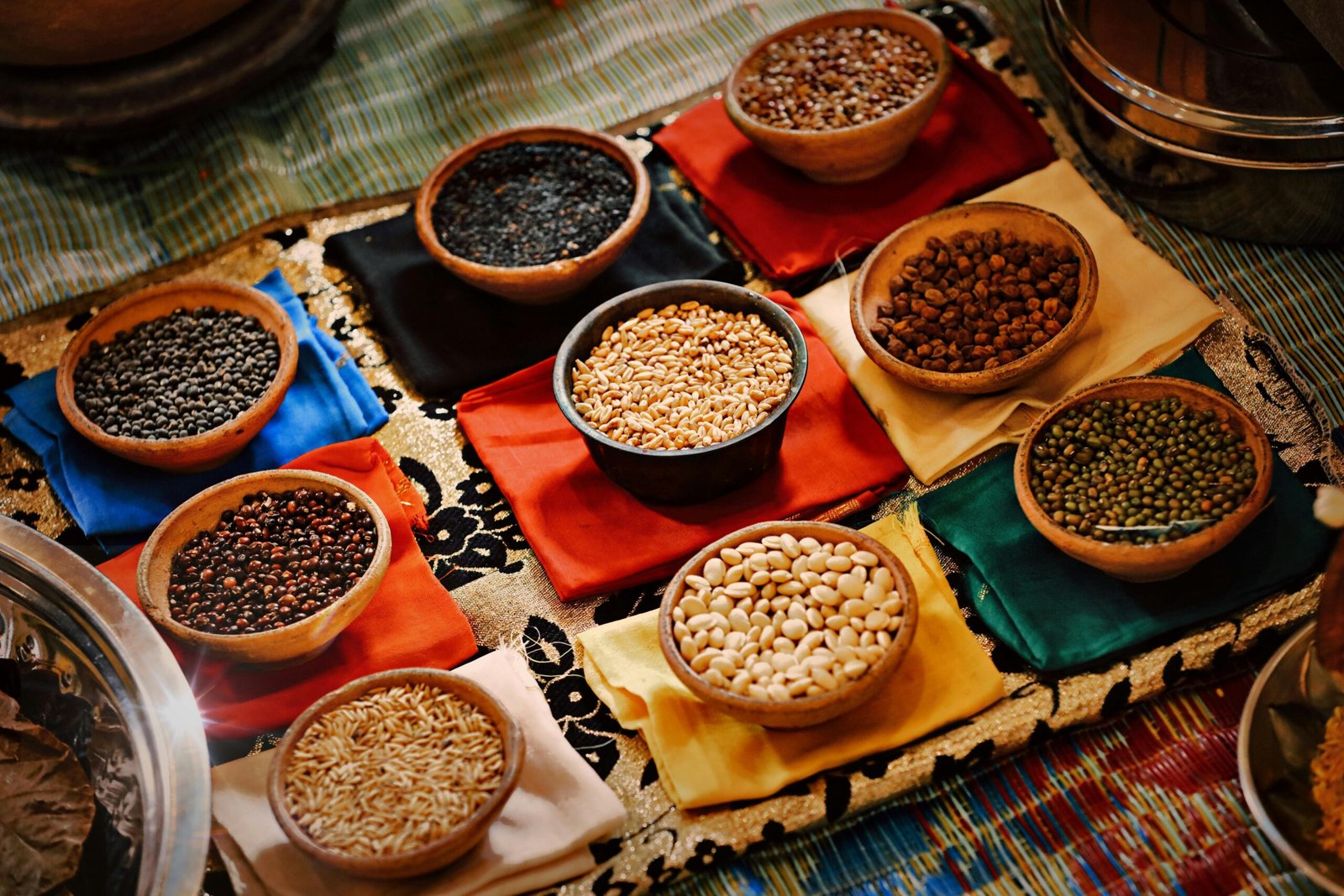 Variety of Indian dals and legumes in traditional clay bowls including moong chana black lentils and beans